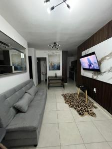 a living room with a couch and a flat screen tv at Noir Beach Suite in Ciudad Madero