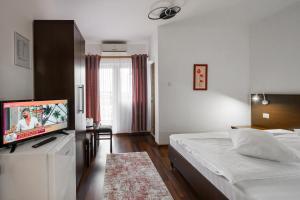 a bedroom with a bed and a flat screen tv at Hotel VULTURUL Pitesti in Piteşti +47 photos