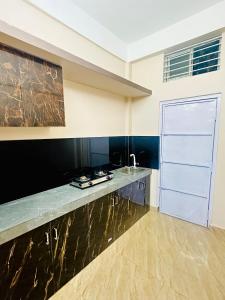 a kitchen with a counter and a large white door at 1BHK Stay in Sibsāgar