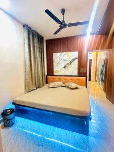 a bed in a room with a ceiling fan at 1BHK Stay in Sibsāgar