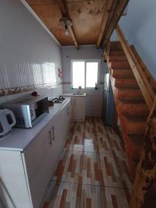 a kitchen with a staircase and a kitchen with a microwave at Casa playa Pullay in Pullay