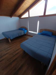 two beds in a room with two windows at Casa playa Pullay in Pullay