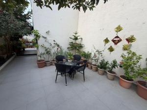 a patio with a table and chairs and potted plants at Spacious Garden Home in Aurangabad