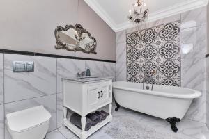 a white bathroom with a tub and a toilet at Frnch on 2nd - Sandton in Johannesburg +19 photos