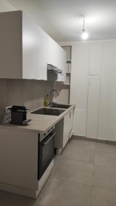 a kitchen with white cabinets and a sink at Charming Bagneux Nest in Bagneux