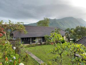 a house with a yard in front of a mountain at Sembalun agro villa&restoran in Sembalun Lawang