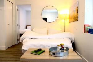 a room with a bed and a table with a mirror at 2BDR Stylish Comfort Parkside in Vancouver