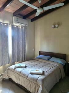 a bedroom with a large bed with two towels on it at La casa de Nimia in Asunción