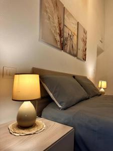 a bedroom with a bed and a lamp on a table at Etruscan Brothers House in Cerveteri