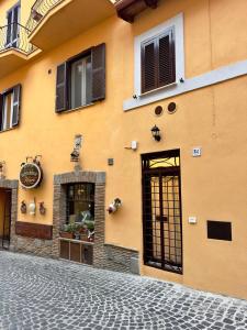 a yellow building with windows on a street at Etruscan Brothers House in Cerveteri