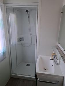 a white bathroom with a shower and a sink at Mobilheim Chalet bei Georg in Seekirchen am Wallersee +22 photos
