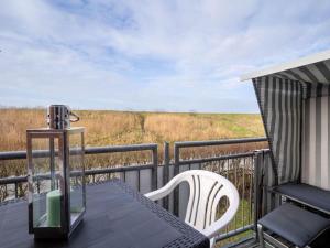 a table and chairs on a balcony with a view at Ferienwohnung, St Peter - Ording in Böhl