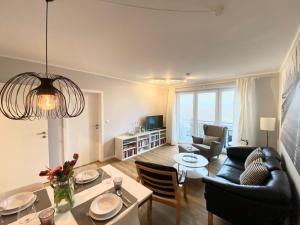 a living room with a couch and a table at Ferienwohnung, St Peter - Ording in Böhl +9 photos
