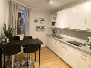a kitchen with white cabinets and a table and chairs at Ferienwohnung, St Peter - Ording in Böhl
