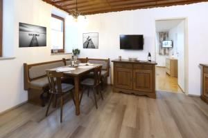 a dining room with a table and chairs and a television at Urbanihof in Jois in Jois