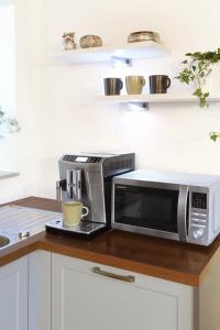 a kitchen with a microwave and a laptop on a counter at Urbanihof in Jois in Jois