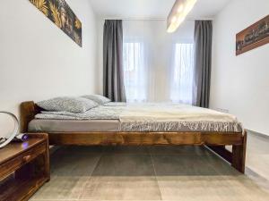 a bedroom with a wooden bed in front of a window at PP Home in Törökbálint