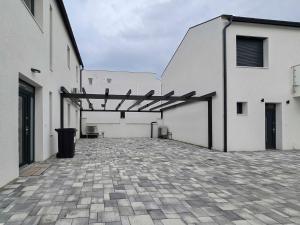 a courtyard with white buildings and a trash can at PP Home in Törökbálint