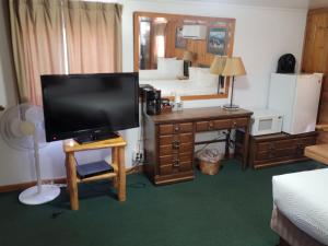 a living room with a television and a desk with a mirror at Trails end motel in Dubois +80 photos