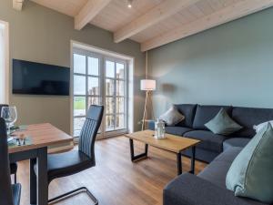 a living room with a couch and a table at Doppelhaushälfte in Karolinenkoog in Karolinenkoog