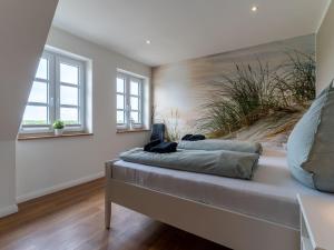 a bedroom with a bed with a painting on the wall at Doppelhaushälfte in Karolinenkoog in Karolinenkoog