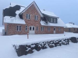 a red brick house with snow on the ground at Doppelhaushälfte in Karolinenkoog in Karolinenkoog