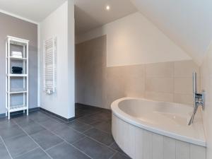 a white bathroom with a tub in a room at Doppelhaushälfte in Karolinenkoog in Karolinenkoog +16 photos