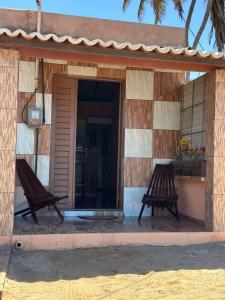 two benches sitting outside of a building at Sereia beach chalé in Icapuí