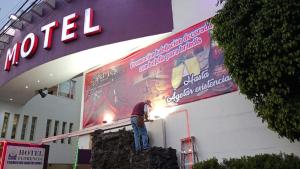 a man working on a sign in front of a building at Hotel Florencia in Mexico City