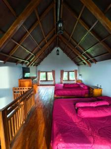 a room with three beds with red sheets at Sembalun agro villa&restoran in Sembalun Lawang
