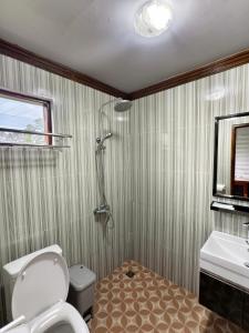 a bathroom with a shower and a toilet and a sink at Sembalun agro villa&restoran in Sembalun Lawang +68 photos