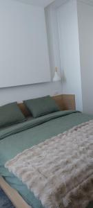 a bedroom with a large bed with green sheets at Apartement LUNA Hotel Zlatni javor in Jahorina
