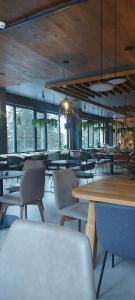 a dining room with tables and chairs and windows at Apartement LUNA Hotel Zlatni javor in Jahorina