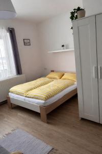 a bedroom with a bed with a yellow blanket at V Talutě in Chyšky