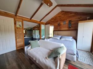 a bedroom with a bed and a couch at Cabaña los Faisanes, Coyhaique in Coihaique