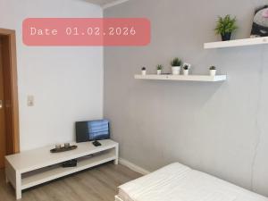 a room with a bed and a tv on a table at FeWo Nina - Monteurwohnung in Weißenfels