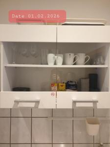a shelf with cups and dishes on it at FeWo Nina - Monteurwohnung in Weißenfels