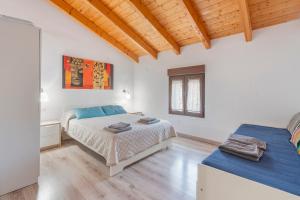 a bedroom with two beds in a room with wooden ceilings at Casa Rural Casa Clemen in Villalba Baja