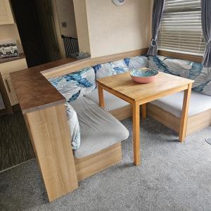 a living room with a table and a couch at KC Caravan Hire in Kinmel Bay