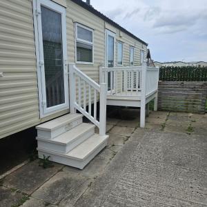 a house with a white staircase next to a house at KC Caravan Hire in Kinmel Bay