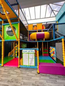 a play room with a playground with a slide at KC Caravan Hire in Kinmel Bay
