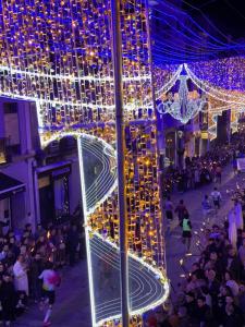 a group of people walking around a street with christmas lights at Hurtado Siete in Jaén