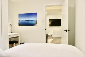 a bedroom with a white bed and a television at 2BDR Stylish Comfort Parkside in Vancouver