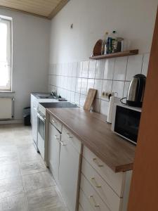 a kitchen with white cabinets and a counter top at FeWo Nina 2 - Monteurwohnung in Weißenfels +10 photos