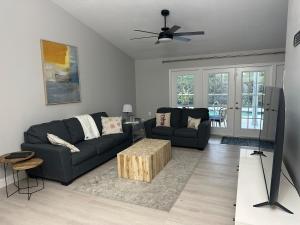 a living room with two couches and a ceiling fan at Florida house, 4br 2bt with private pool oasis in Naples