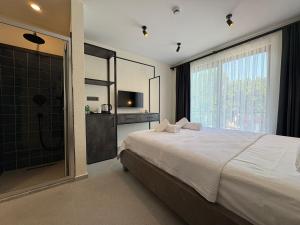 a bedroom with a large bed and a shower at Arıcan Pansiyon in Fethiye