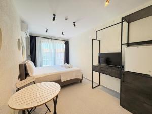 a bedroom with a bed and a table and a tv at Arıcan Pansiyon in Fethiye