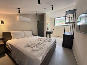 a bedroom with a bed with white sheets and a window at Arıcan Pansiyon in Fethiye +14 photos