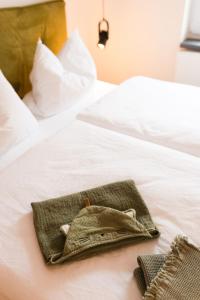 a purse sitting on top of a white bed at Appartment 1 Frau Isi in Mellrichstadt