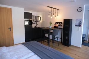 a bedroom with a bed and a table and a kitchen at Alpencabin Montafon in Vandans